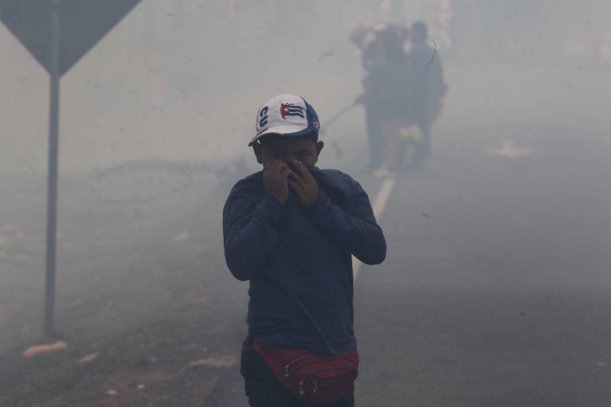 Un menos se cobre el rostro ante la densa capa de humo por incendios.