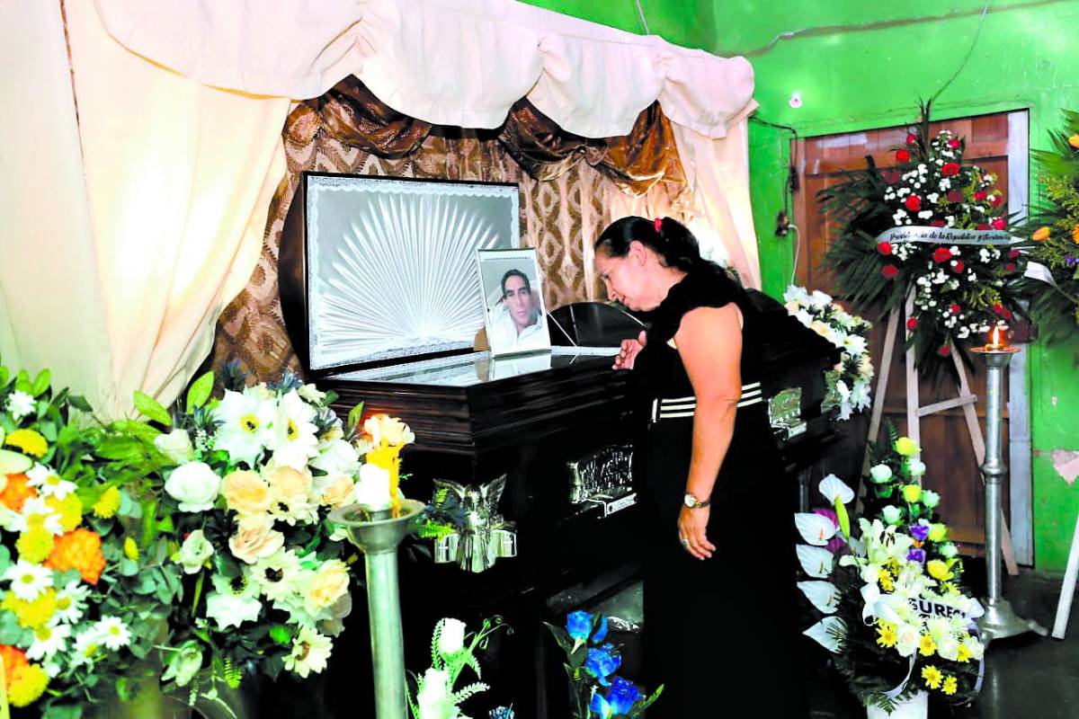 Una pariente de Ignacio Ayala se acerca al féretro para apreciar a su familiar antes del sepelio.