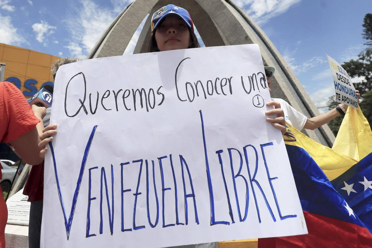 Una joven venezolana sostiene una pancarta que quiere una Venezuela libre.