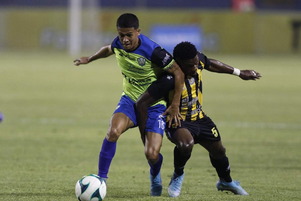 Cristian Cálix disputando el balón con Franklin Flores.