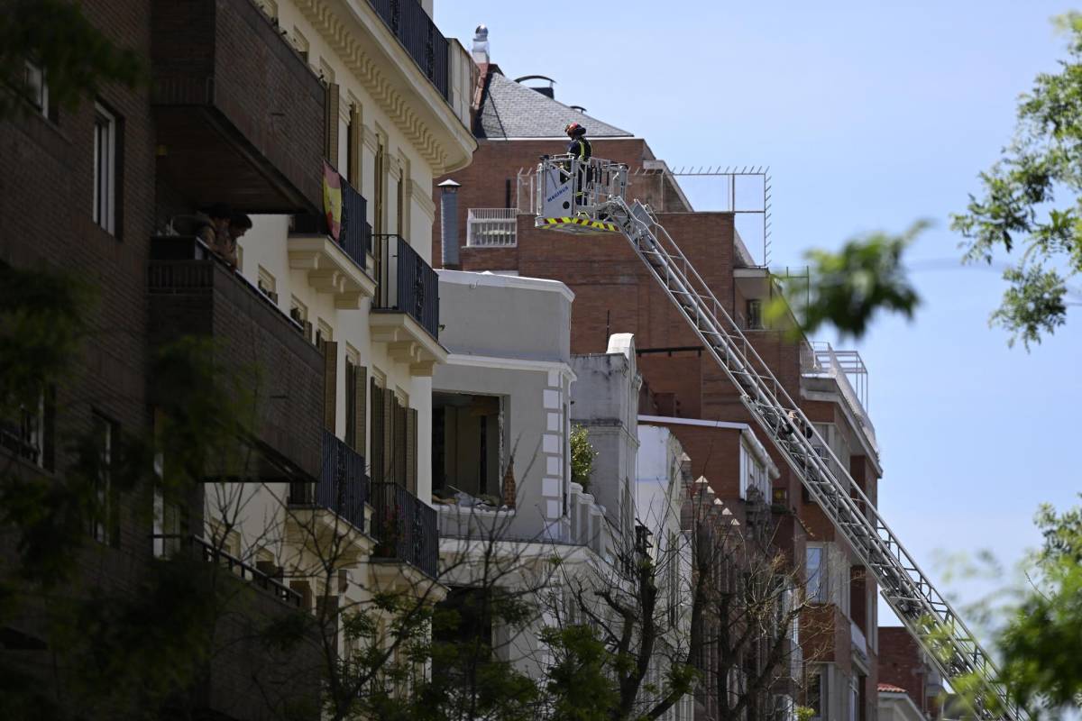 Un bombero inspecciona un edificio desde una escalera, mientras los servicios de emergencia buscan a dos personas desaparecidas tras una fuerte explosión que hirió a 18 personas en el barrio de Salamanca de Madrid, el 6 de mayo de 2022.