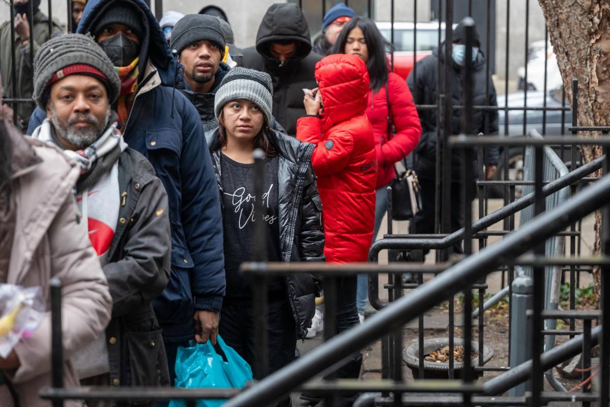 Un grupo de migrantes hace fila frente a una Iglesia en Nueva York para recibir alimentos.