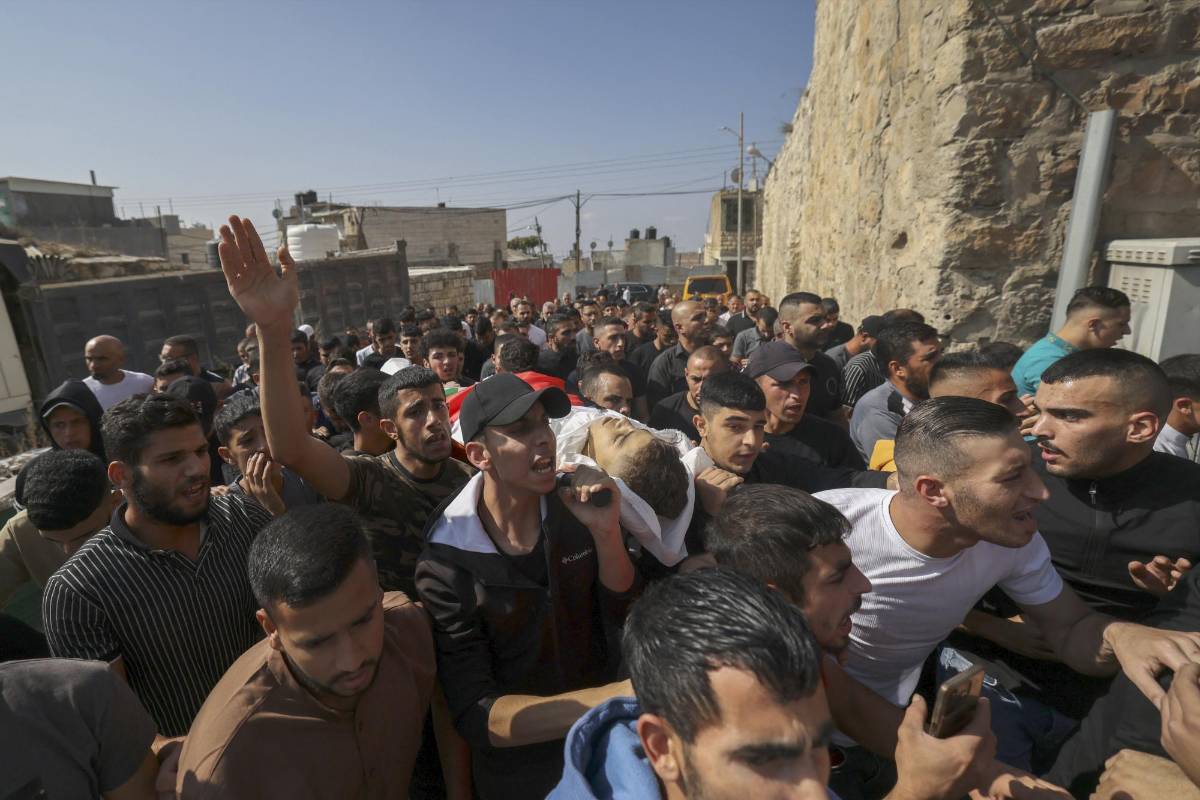 Palestinos cargan el cuerpo de Abdullah Miqbel, de 16 años, asesinado un día antes en enfrentamientos con las fuerzas de seguridad israelíes tras las protestas en apoyo de Gaza, durante su funeral en la aldea de Beit Omar al norte de Hebrón, en la Cisjordania ocupada, el 1 de noviembre de 2023.