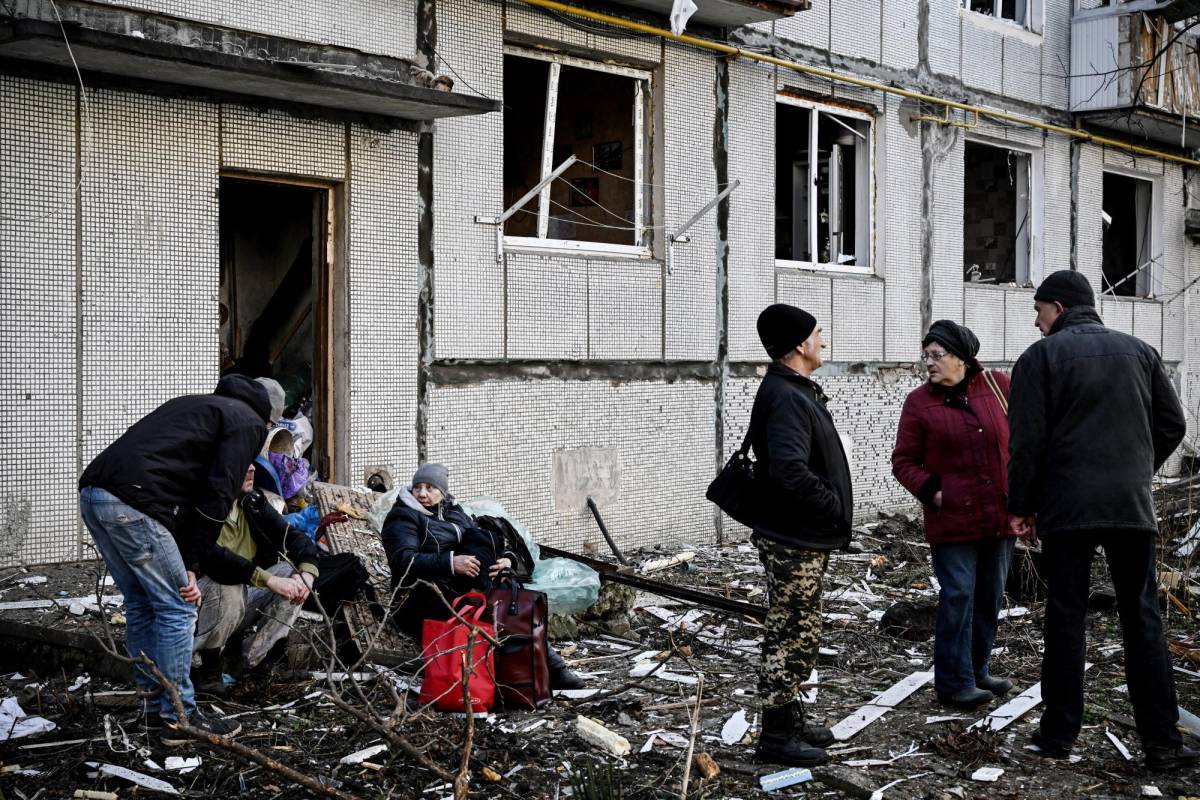 La gente se para fuera de un edificio destruido después de los bombardeos en la ciudad de Chuguiv, en el este de Ucrania, el pasado 24 de febrero de 2022.