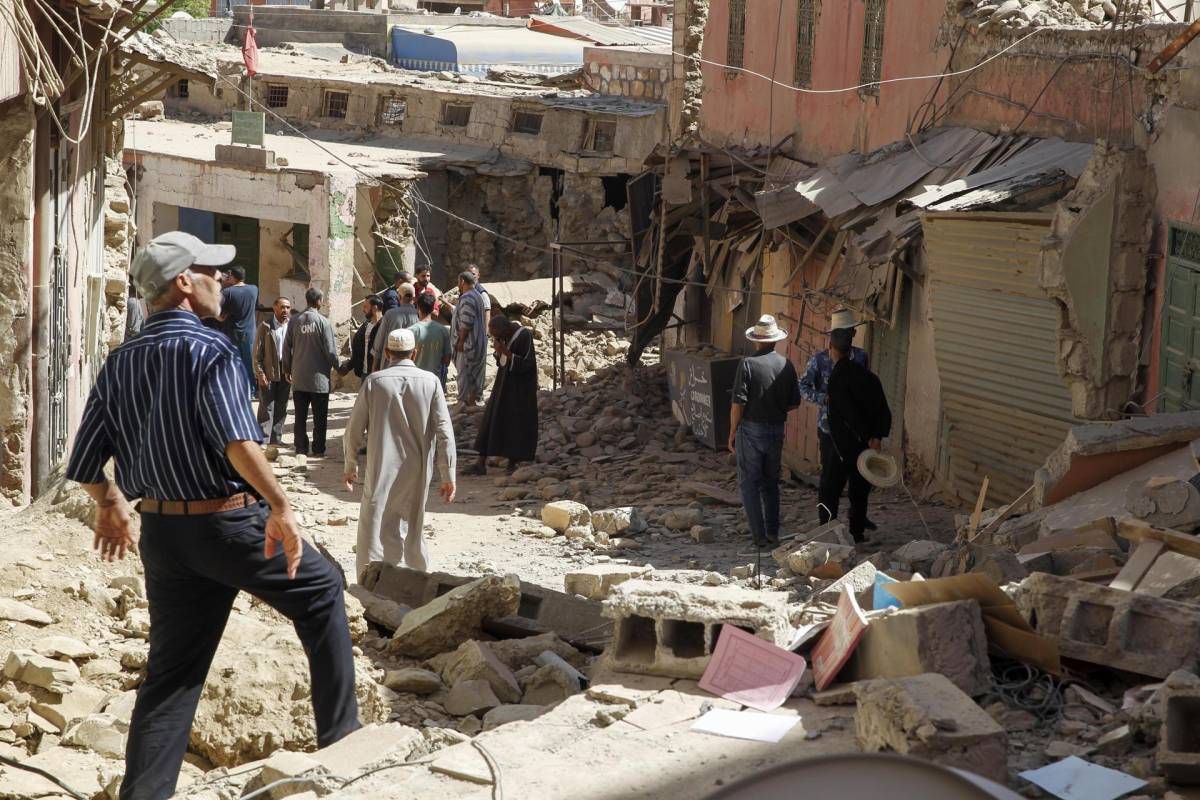 Varios hombres caminas por las calles de Amizmiz, situada a unos 30 kilómetros del epicentro del terremoto, en las faldas del Atlas, que amaneció este sábado llena de cascotes y escombros de edificios derruidos tras el terremoto que sacudió el suroeste del país la pasada madrugada.