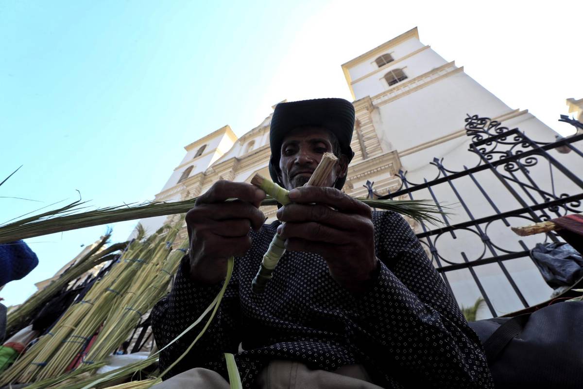 Campesinos hondureños venden ramos de palma este viernes, en la Catedral San Miguel Arcángel de Tegucigalpa (Honduras).