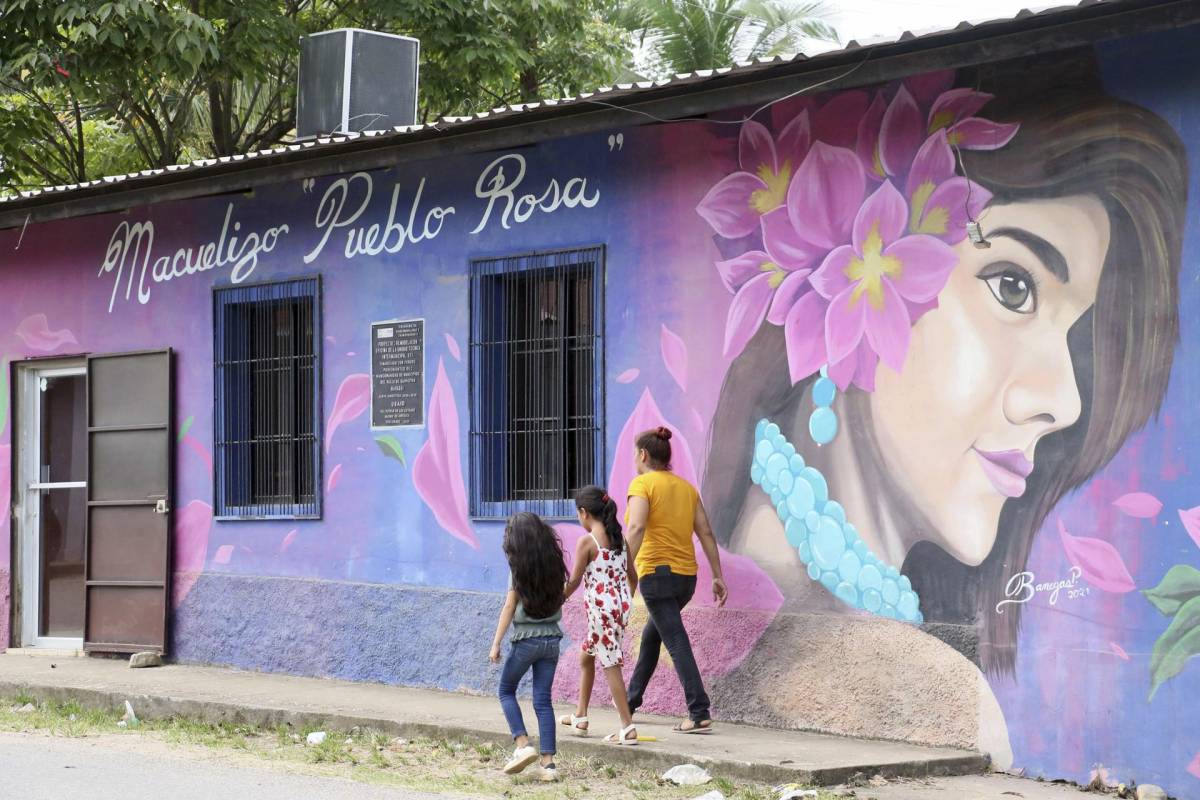 Una mujer y dos niñas caminan el 18 de agosto de 2023 por una calle del municipio de Macuelizo, en el norte de Honduras.