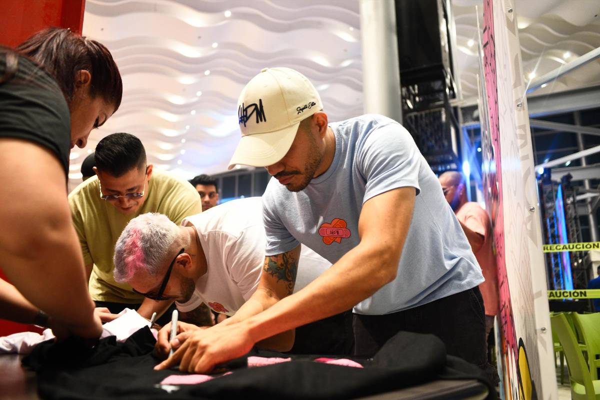 Los Hijos de Morazán firman algunas de las camisetas que adquirieron sus fans.
