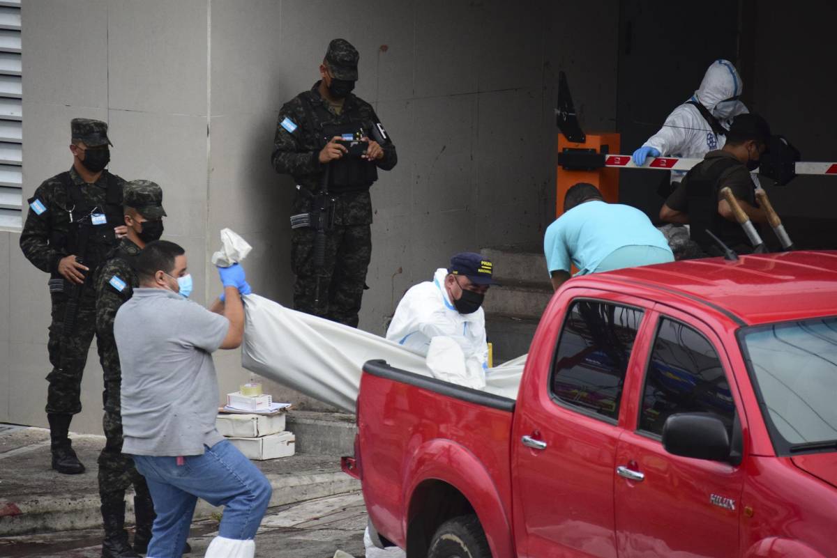 Policías y expertos forenses realizan el levantamiento de cuatro personas asesinadas, en Tegucigalpa (Honduras).