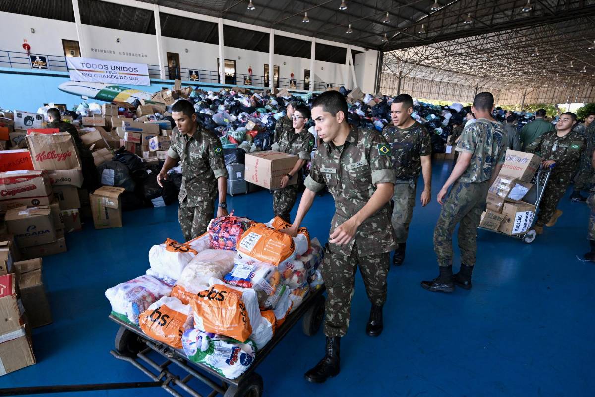 Militares brasileños distribuyen alimentos a los damnificados por las inundaciones.