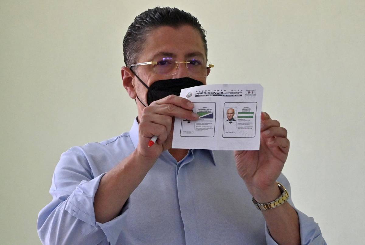 El candidato presidencial costarricense Rodrigo Chaves, por el partido Progreso Socialdemócrata, muestra una boleta mientras vota durante la segunda vuelta de las elecciones presidenciales en San José, el 3 de abril de 2022. (Foto por Luis ACOSTA / AFP)