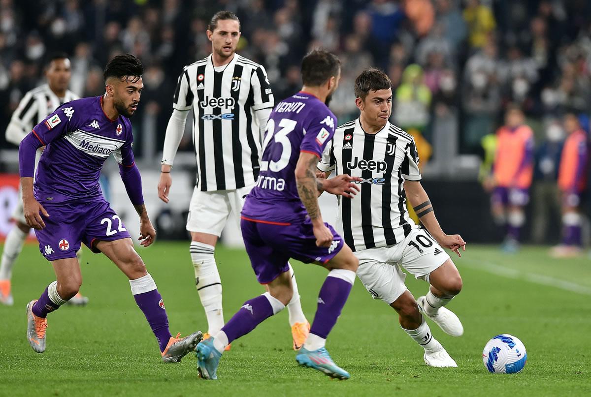 Paulo Dybala conduce el balón ante la marca de dos jugadores de la Fiorentina.
