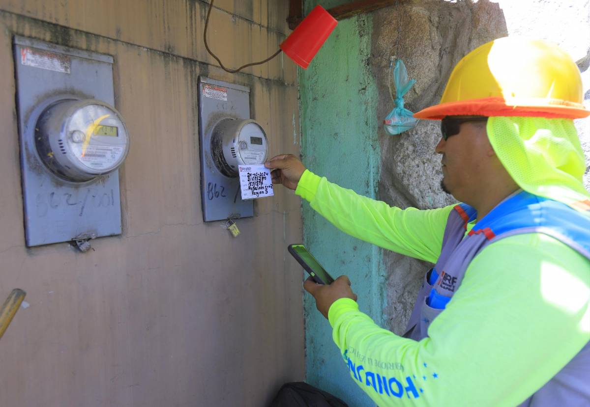 Un empleado de la Enee revisa los contadores de unas viviendas en una residencial del sector noroeste.