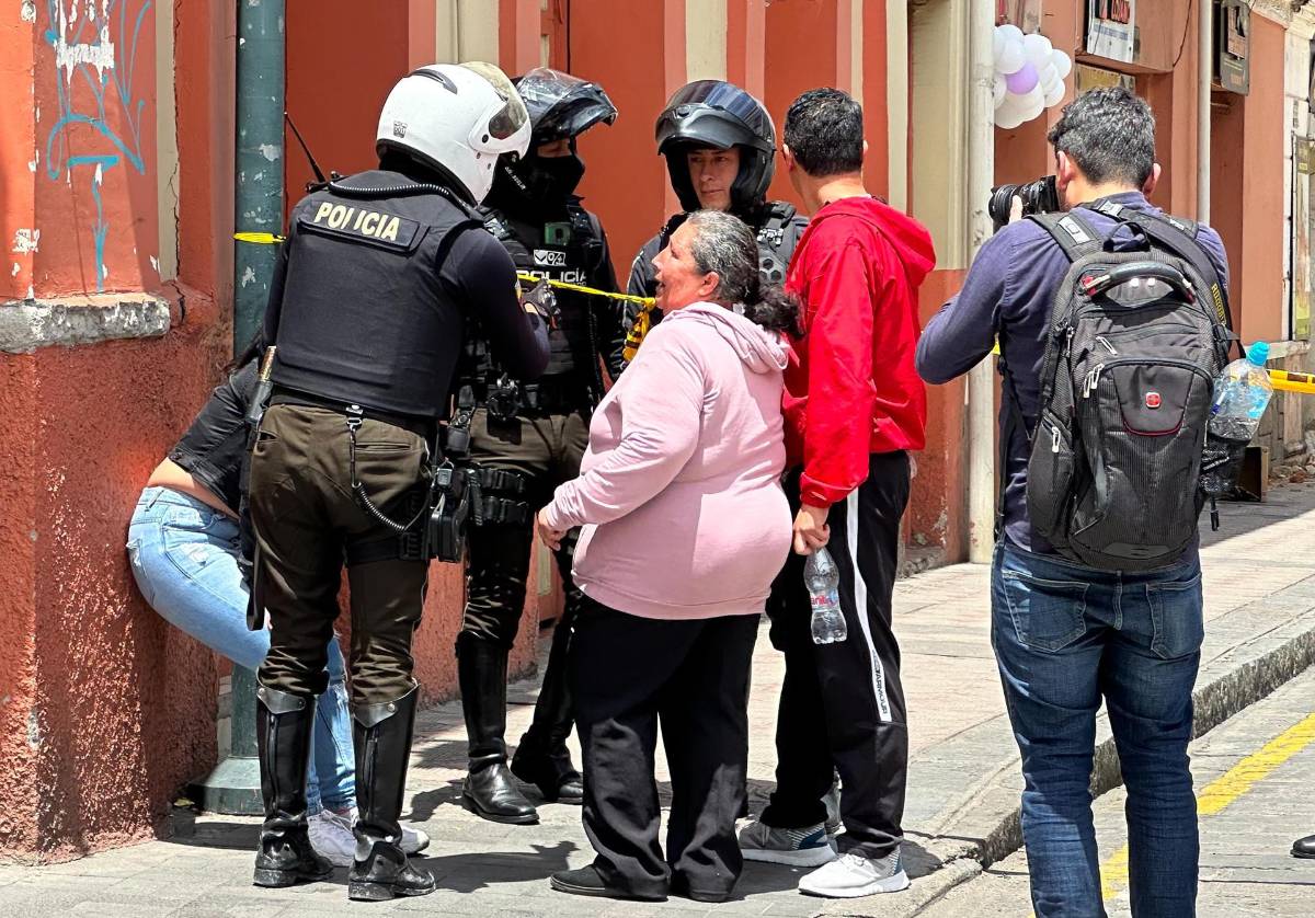 Personas hablan con la policia en la zona de los daños ocasionados por el sismo de magnitud 6,5 en la escala abierta de Richter en la ciudad de Cuenca (Ecuador).