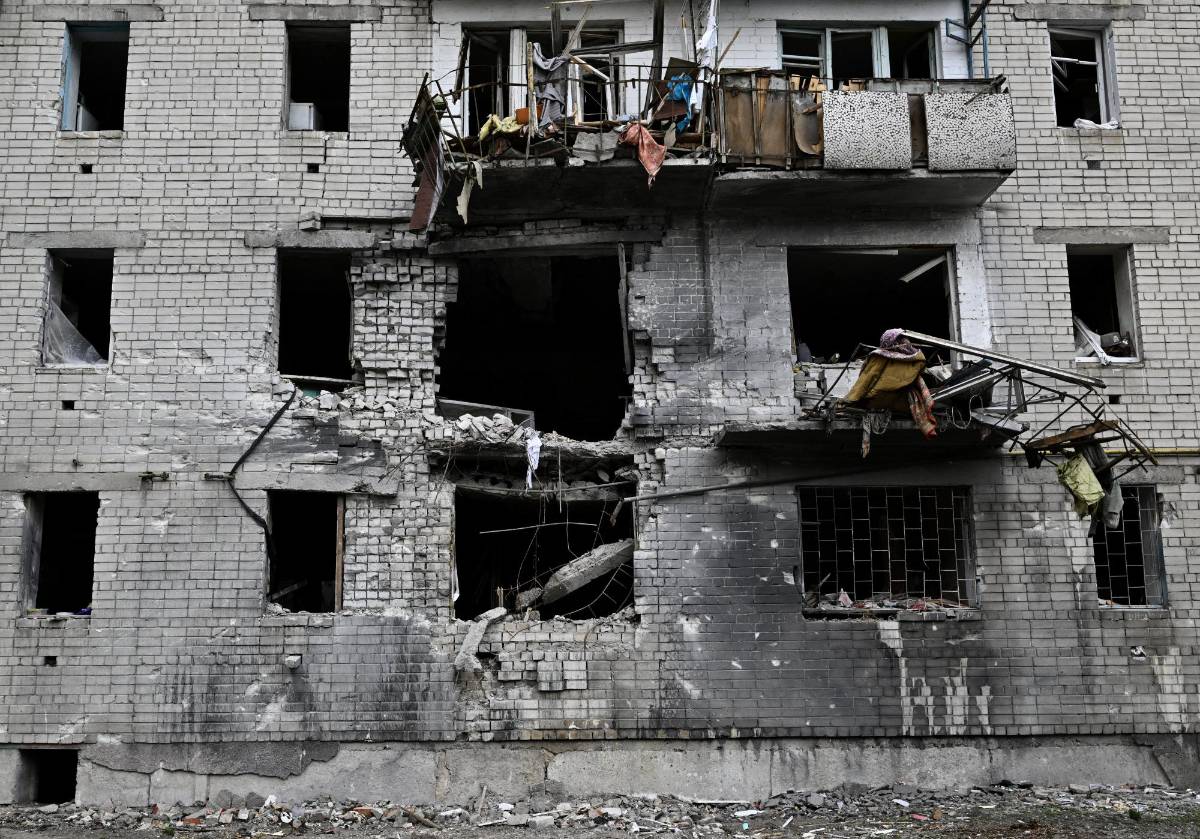 A photograph taken on May 3, 2022 shows a crater next to a heavily damaged residential building in the northern Ukrainian city of Chernigiv, amid the Russian invasion of Ukraine. - Russia's withdrawal from Chernigiv after a month-long assault left behind a devastated city that Ukraine will needs massive foreign aid, and many years of work, to restore. (Photo by Genya SAVILOV / AFP)