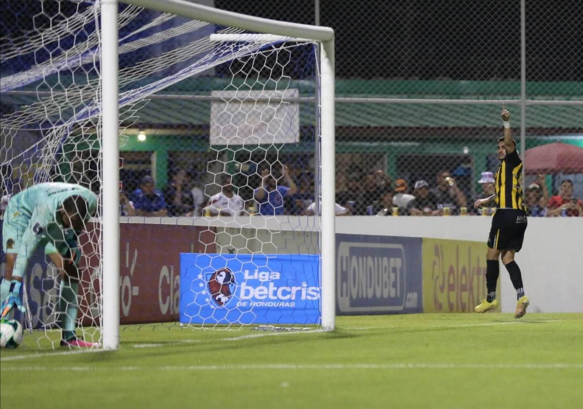 Ramiro Rocca celebra su gol mientras Edrick Menjívar saca la pelota del fondo de las reds.