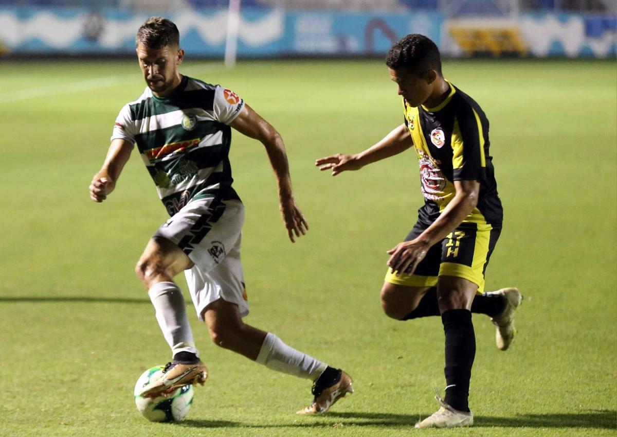 Guillermo Chavasco conduce el balón ante la marca de Héctor Oliva.