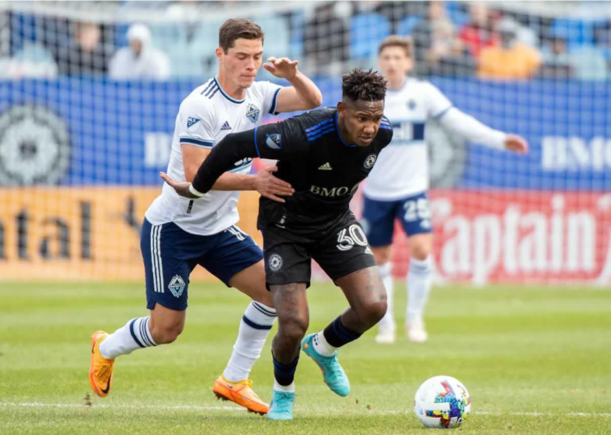 Romell Quioto cubriendo el balón de la marca de un jugador del Vancouver Whitecaps.