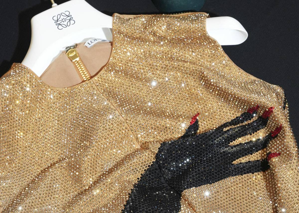 Este look es un satén técnico con aplicaciones de cristales, trampantojos con motivos de manos y guantes de látex negro.