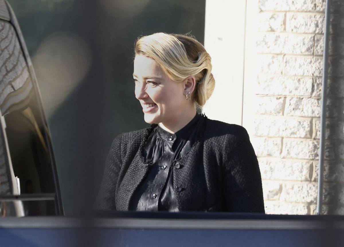 La actriz Amber Heard deja la corte con una evidente sonrisa.