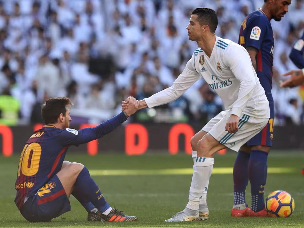 Cristiano Ronaldo ayudando a Leo Messi a levantarse en un Clásico Real Madrid vs Barcelona en el Bernabéu.