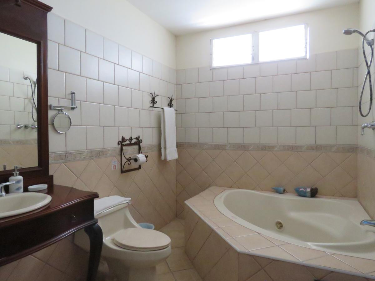 La habitación doble con dos camas matrimoniales, baño con bañera y tv.