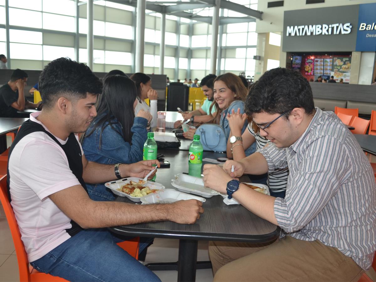 Este grupo de compañeros de trabajo aprovecha la hora del almuerzo para disfrutar de los deliciosos platillos del food court de Mega Mall, mientras tienen una agradable conversación.