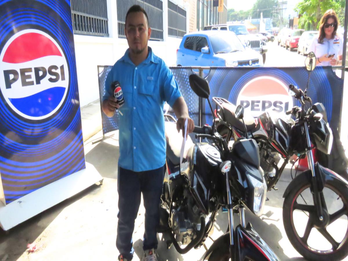 Allan Acosta posa felizmente con su nueva motocicleta Genesis.