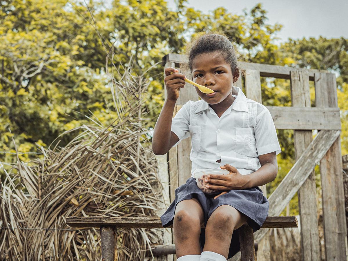 <i>Niños y niñas hondureños disfrutando de una ración diaria de alimentos nutritivos. </i>