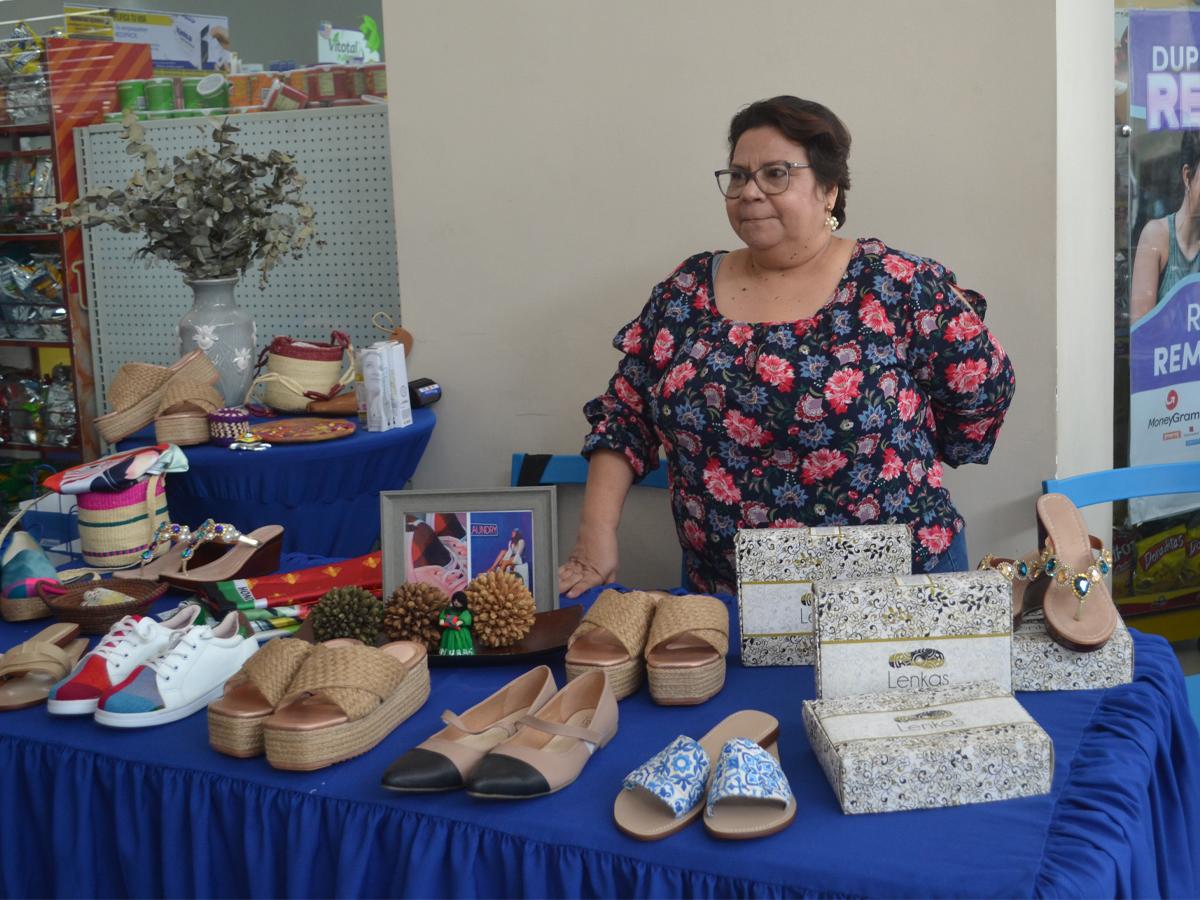 Una beneficiaria de la alianza entre Diunsa y Voces Vitales de Honduras mostrando sus productos durante la firma del convenio entre ambas organizaciones.