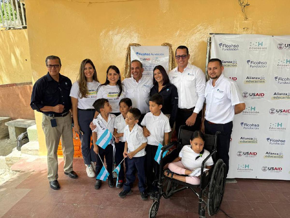 Representantes de Fundación Ficohsa y USAID junto a un grupo de niños de Centro de Educación Básica José Cecilio del Valle.
