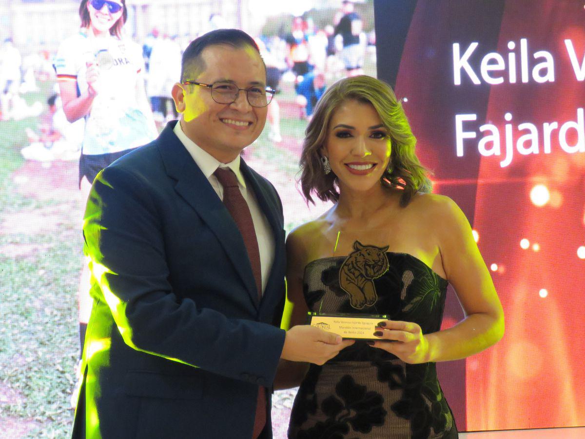 Keila Vanessa Fajardo recibe su reconocimiento por parte de Miguel Mejía.