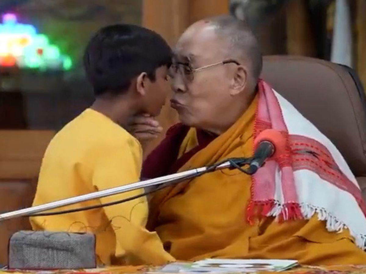 Fotografía del Dalai Lama besando a un niño en la boca.