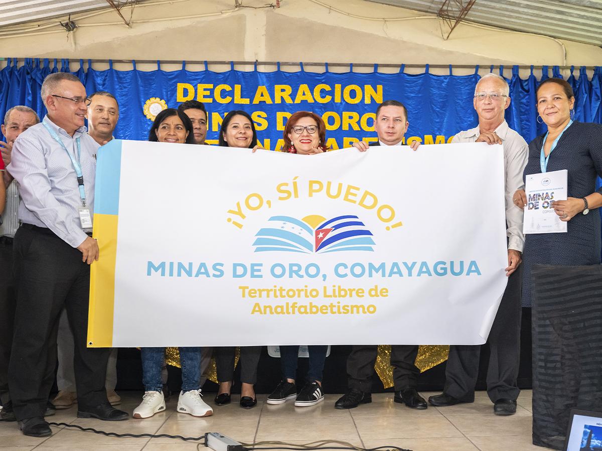 Una ceremonia oficial donde se declara a un municipio libre de analfabetismo, un hito en la lucha por la educación.