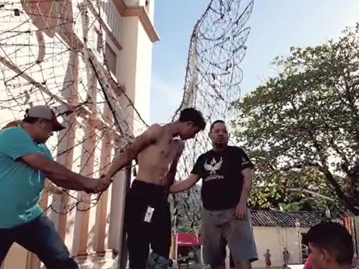 Dos de los pobladores están sujetando al supuesto ladrón.