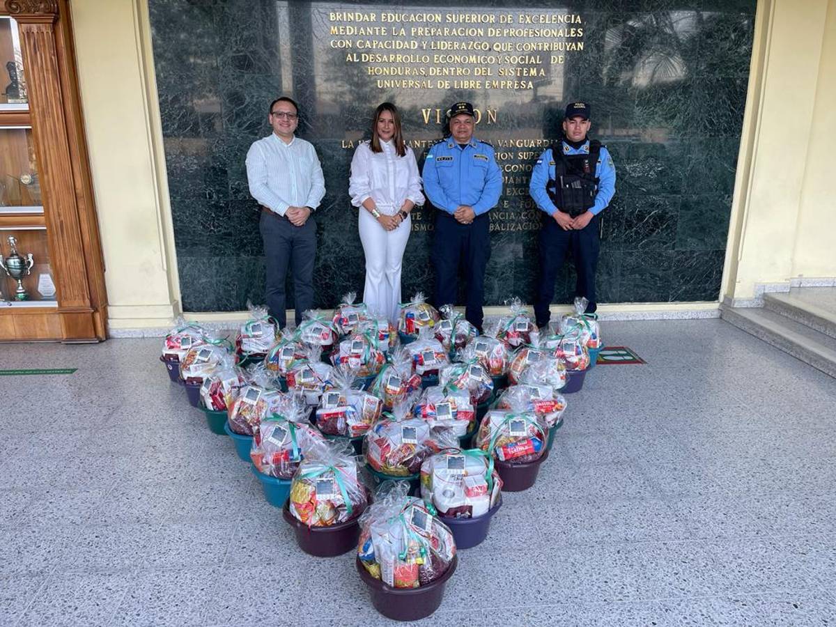 Representantes de UTH y la policía durante la entrega de las canastas.