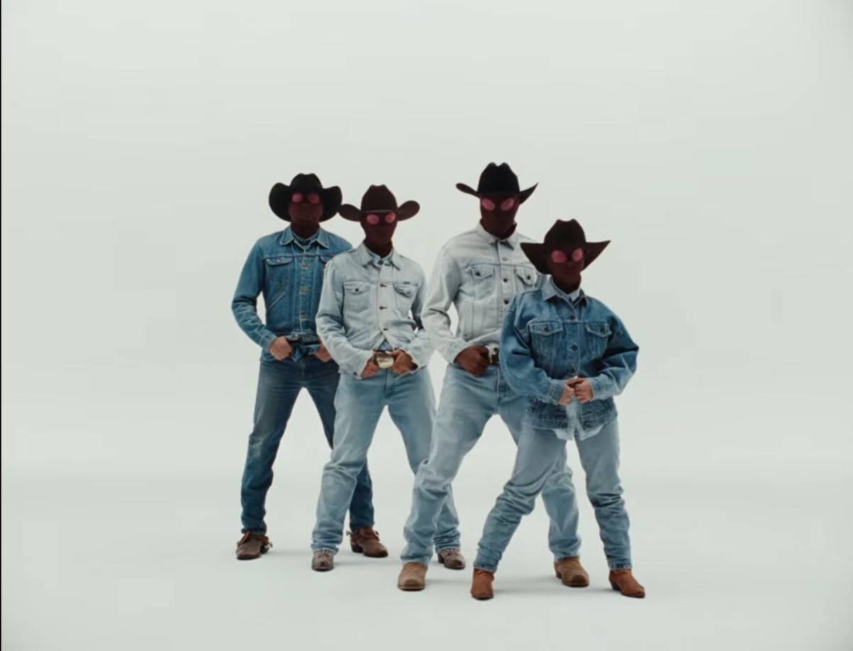 El cantante en su reciente canción que fue estrenada hace unas horas, volvió a sorprende a sus seguidores con su vídeo musical, ya que en este sus bailarines están vestidos con un traje de mezclilla, botas y sobrero.