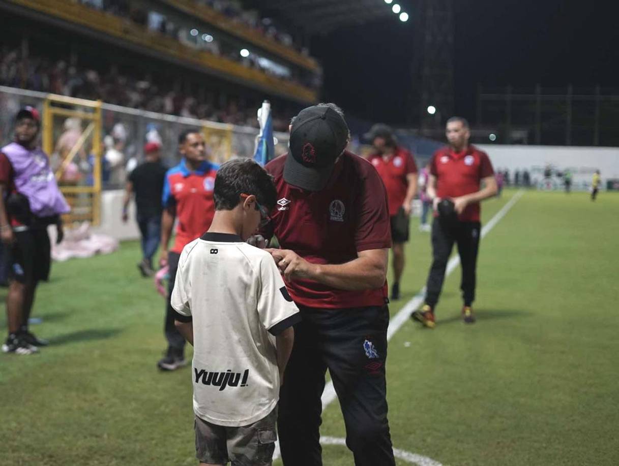 Pedro Troglio firmándole la camiseta al pequeño aficionado del Olimpia tras el final del partido.
