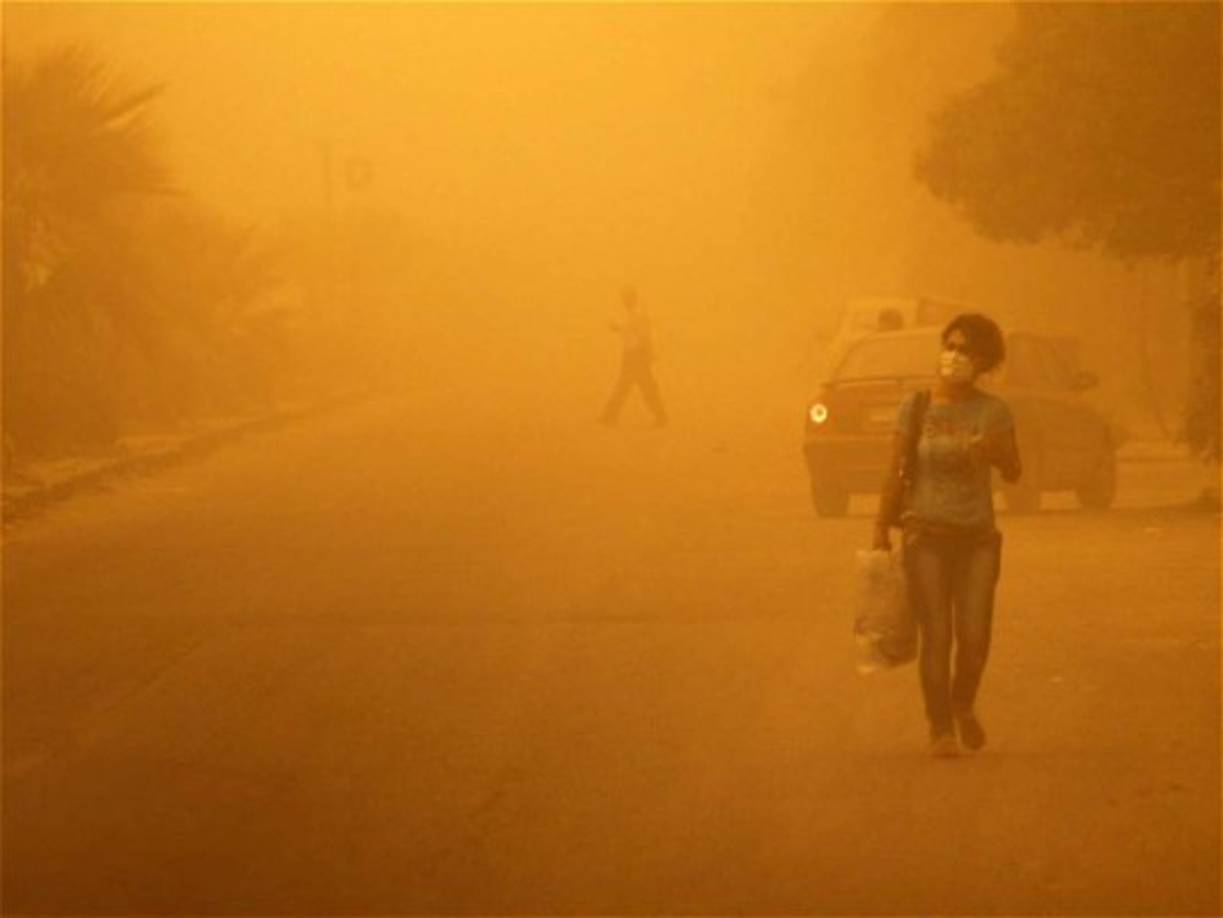 Una mujer camina en Homs, Siria, durante la tormenta de arena.