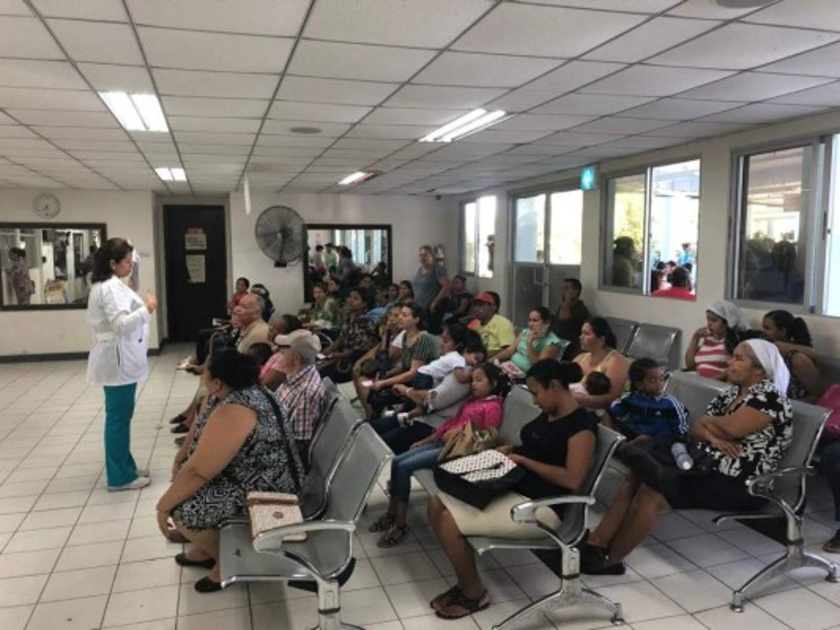Una doctora informa a los pacientes que sus compañeros están en asambleas informativas.