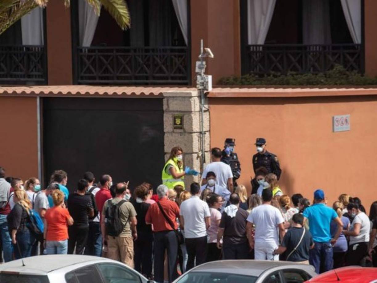 Un psicólogo habla hoy con un grupo de trabajadores fuera del H10 Costa Adeje Palace Hotel en La Caleta, donde cientos de personas fueron confinadas después de que un turista italiano fue hospitalizado con un presunto caso de coronavirus.