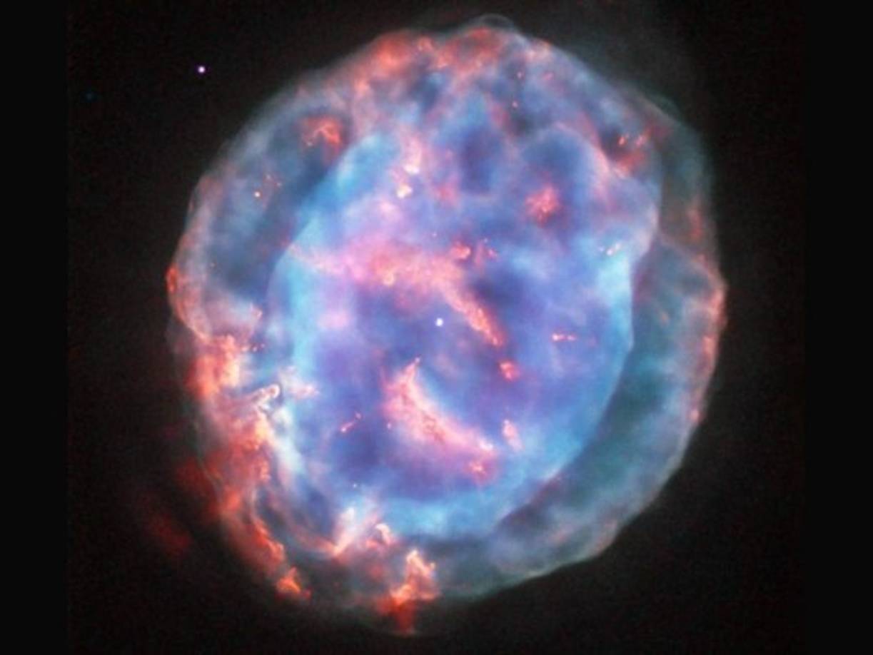 Nebulosa de la Pequeña Gema.<br/><br/>Esta colorida burbuja es una nebulosa planetaria llamada NGC 6818, también conocida como la nebulosa la Pequeña Gema. <br/>Se encuentra en la constelación de Sagitario a unos 6.000 años luz de distancia de la Tierra. <br/><br/>Los científicos creen que el viento estelar de la estrella central propulsa el material que sale, esculpiendo la forma alargada de NGC 6818. La imagen fue captada por el telescopio Hubble, utilizando diferentes filtros para revelar una visión distinta de la nebulosa
