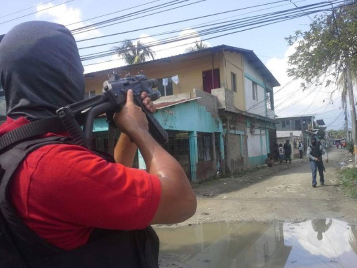 Agentes de la Dirección Policial de Investigaciones (DPI) resguardan la zona donde se realizan los allanamientos.