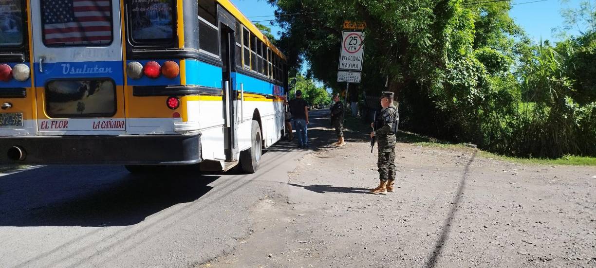 Militares resguardan a los ciudadanos en las paradas de autobuses en El Salvador.