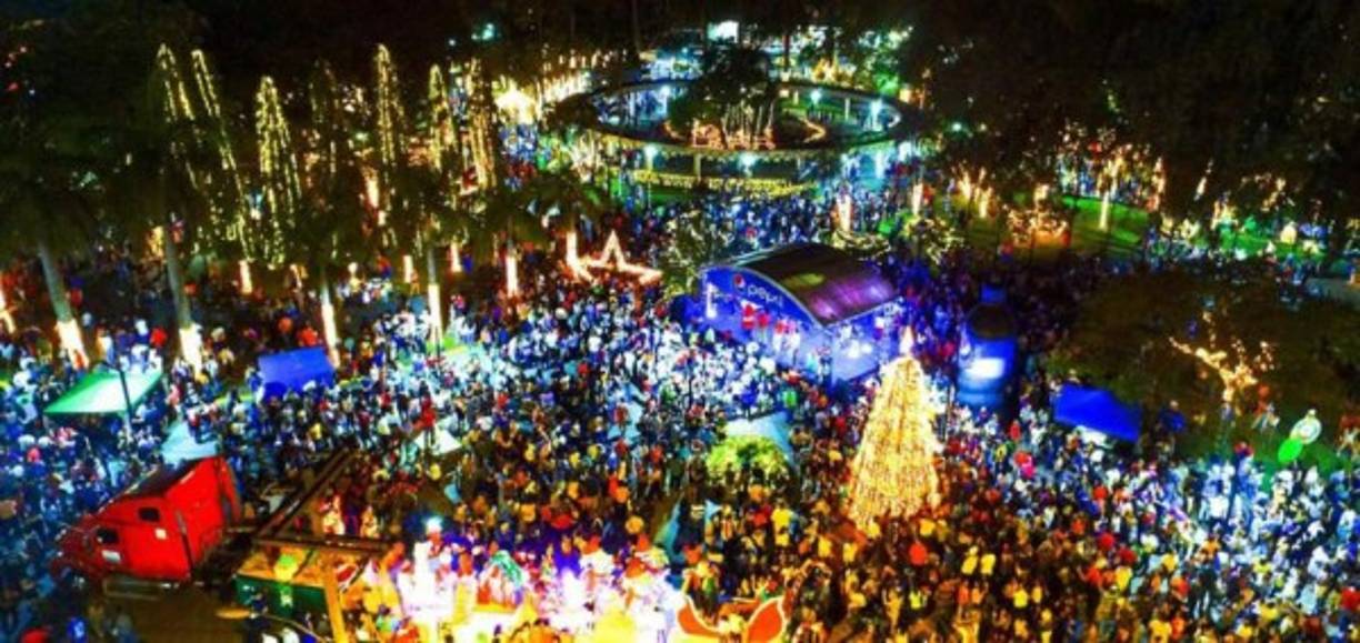 "Familias de Puerto Cortés pasan momentos agradables entre las luces de colores en la Navidad Dorada en el parque central."