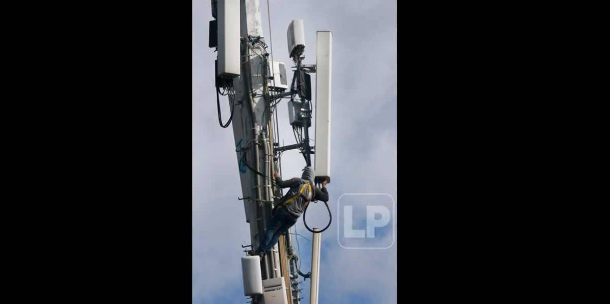 Un empleado de una compañía de celulares trabajando en mejorar la señal de velocidad de ancho de banda en el estadio Nacional.