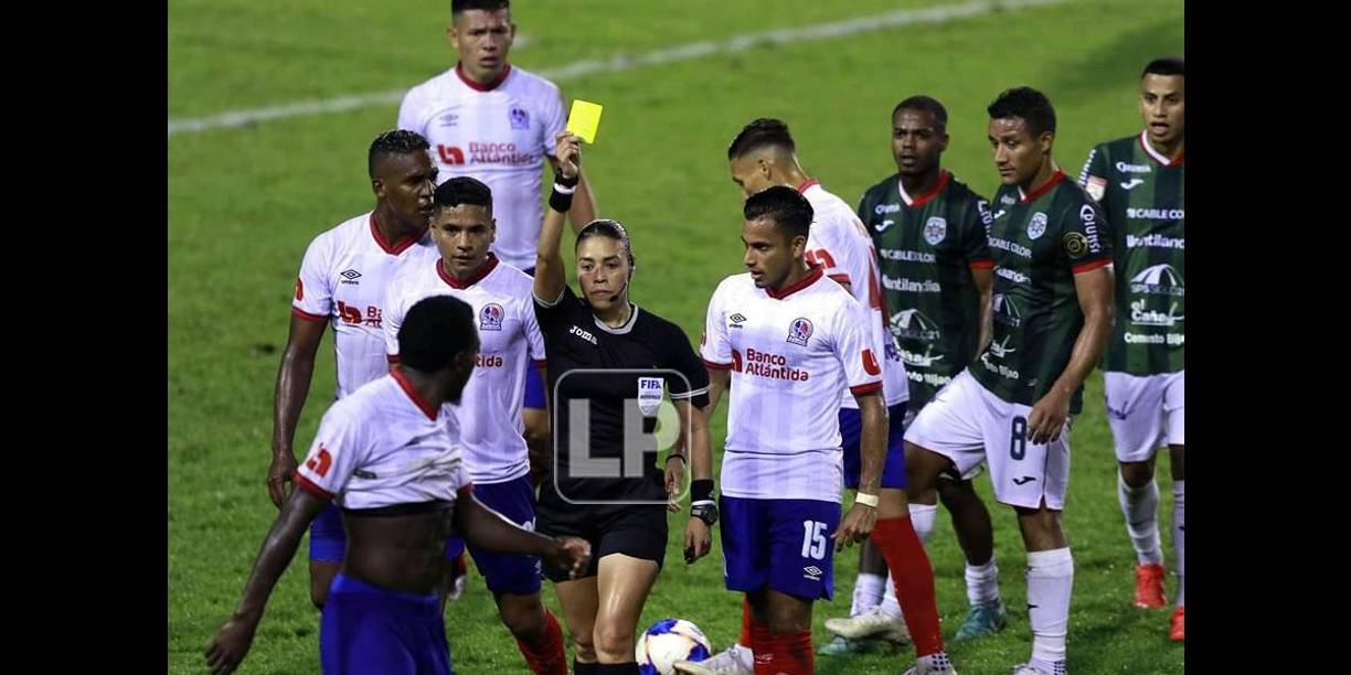 La árbitra Melissa Pastrana le muestra tarjeta amarilla a José García del Olimpia.