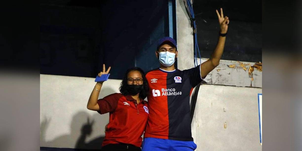 Dos aficionados del Olimpia saludando a la cámara de Grupo OPSA en el estadio Nacional durante el juego ante Marathón.