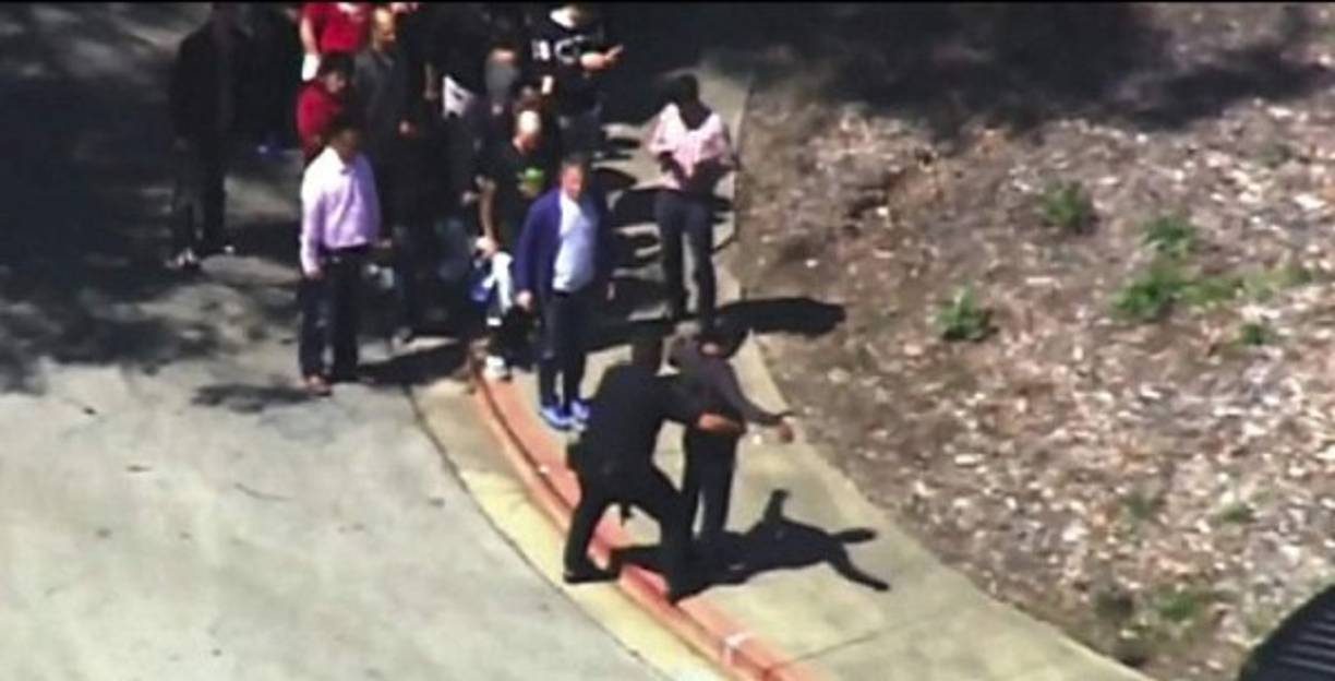 Imágenes de la televisión local muestran a empleados abandonando las instalaciones, cada uno requisado por oficiales.