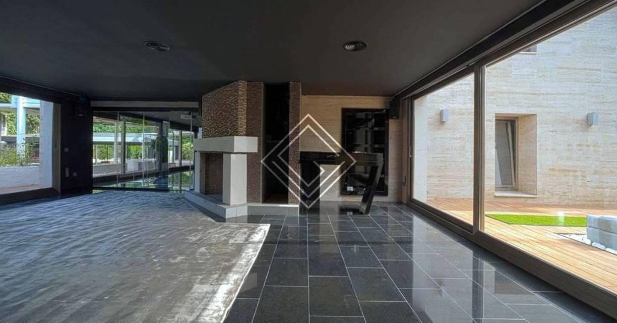 Además, al ingresar, se aprecia un amplio hall de entrada, con aseo, y que da acceso al salón, rodeado de grandes ventanales que van del suelo al techo. 